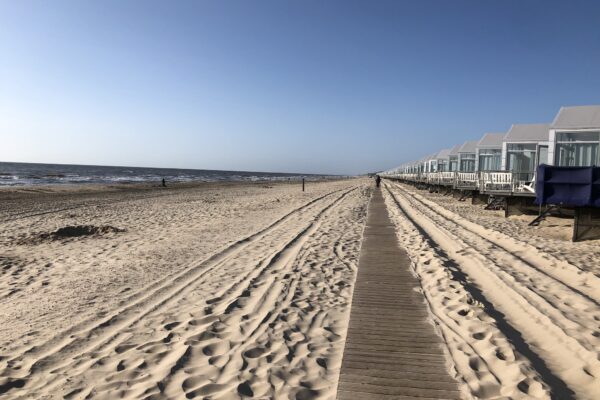 Niederlande Strand mit Meer zur Linken und Häusschen zur rechten Seite