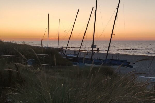 Ostsee Kühlungsborn Strand mit Botten bei Sonnenuntergang